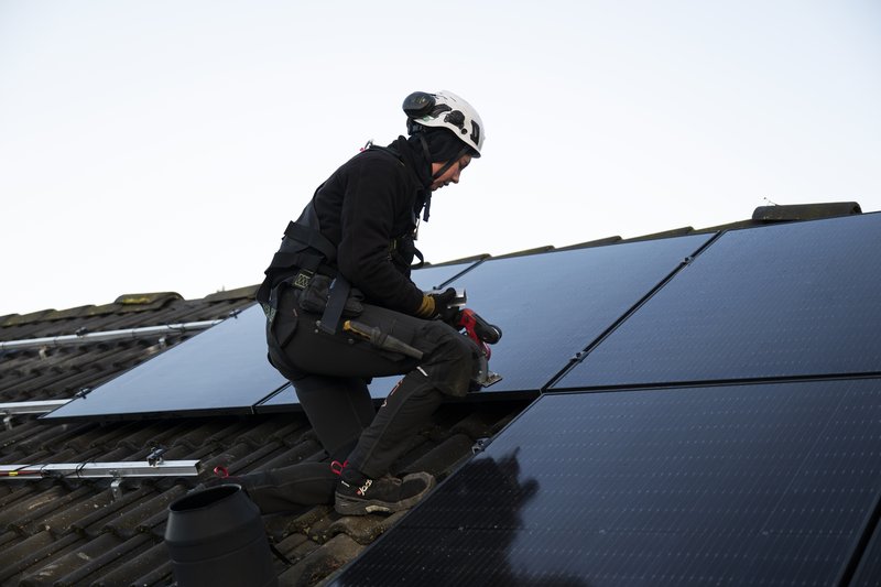 Installateur montiert PV-Anlage auf einem Dach. (Fazit Inselanlage)