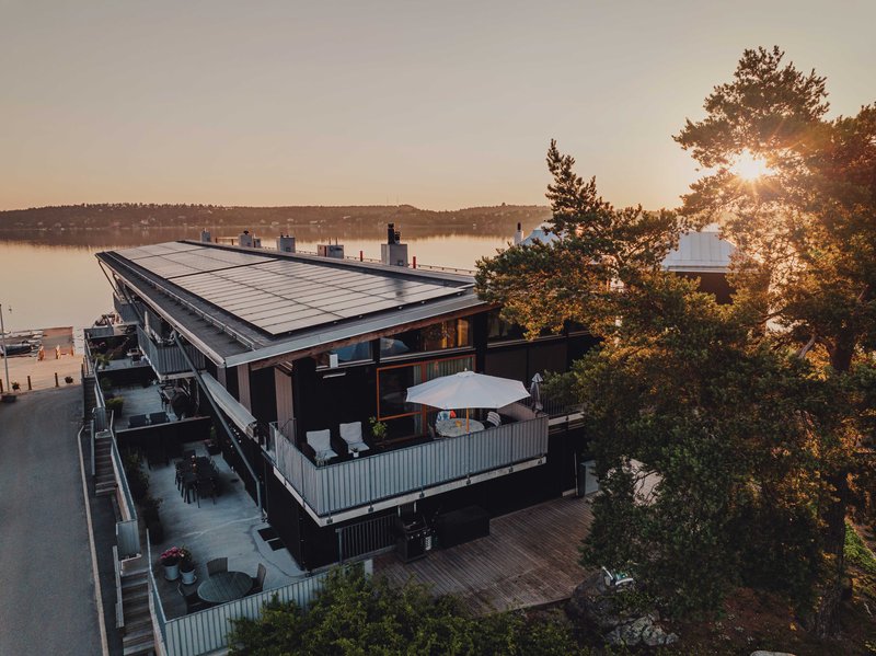 Haus am See mit Solaranlagen auf dem Dach.