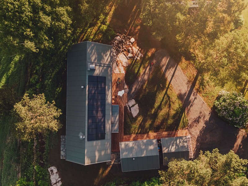 Wie Photovoltaik den Wert deiner Immobilie steigern kann. Haus mit Solarmodulen in der Natur.