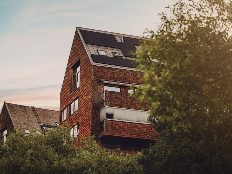 Mehrfamilienhaus mit PV-Anlagen auf dem Dach. (Photovoltaikanlage selbst anmelden?)